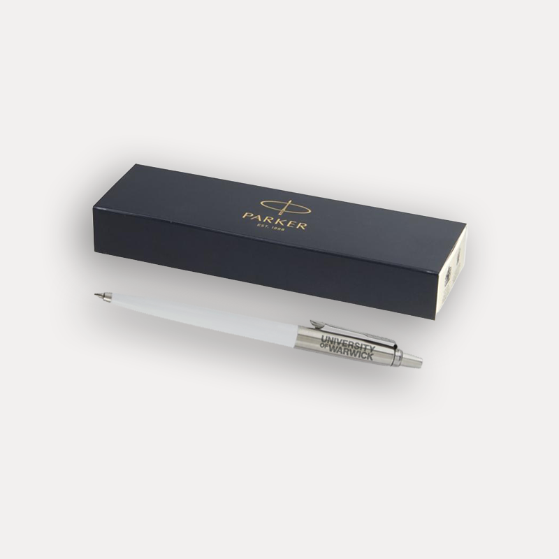 A white Parker University of Warwick ballpoint pen with a silver clip and barrel, displayed next to its presentation box with gold lettering on a light grey background.
