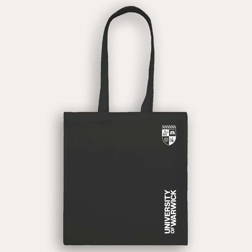 A black canvas tote bag with white printed text reading 'UNIVERSITY OF WARWICK' and a small black crest logo near the bottom left, shown against a light gray background.